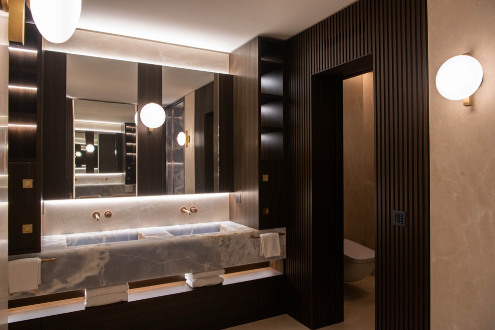 Double basin and a backlit mirror in the principal bathroom